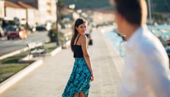 Young,Attractive,Woman,Flirting,With,A,Man,On,The,Street.flirty